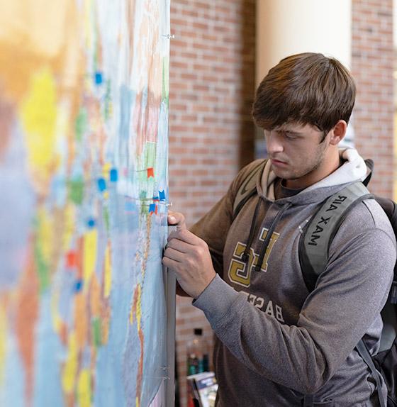 男学生把别针放在地图上